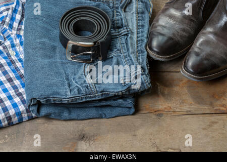 Jeans, Belt and leather boots, on a rustic wooden background Stock Photo