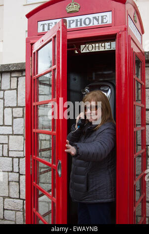 A woman using the old fashioned telephones of the British Commonwealth on the Rock of Gibraltar.