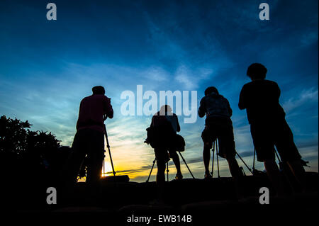 silhouette of photographer taking picture of landscape during sunrise Stock Photo