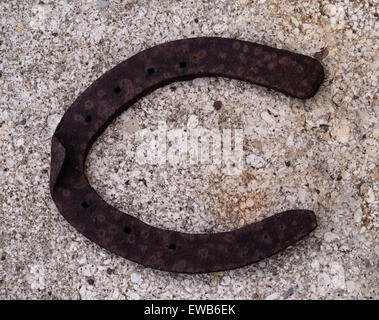 Old iron horseshoe on concrete path background Stock Photo