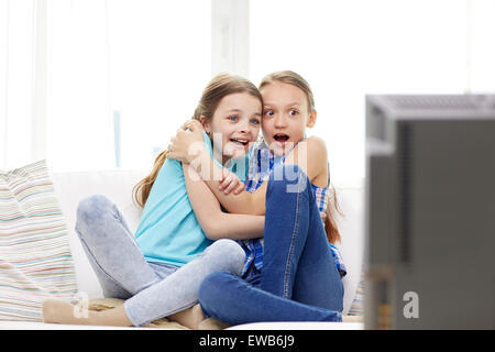 scared little girls watching horror on tv at home Stock Photo