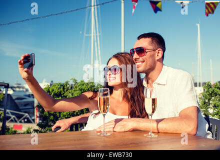 smiling couple drinking champagne at cafe Stock Photo