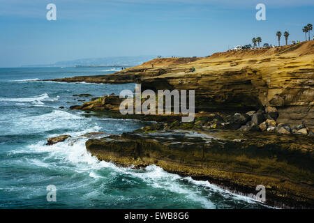 Waves crashing on cliffs along the Pacific Ocean at Sunset Cliffs Natural Park, Point Loma, California. Stock Photo