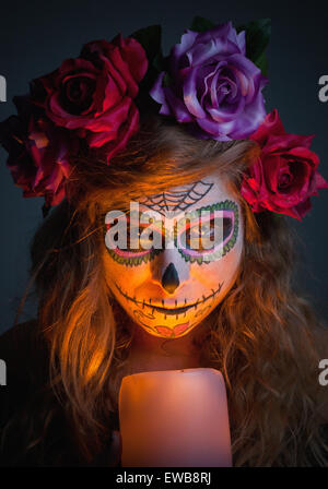 Halloween witch. Beautiful woman wearing santa muerte mask portrait with a candle. Stock Photo