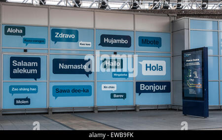 Artwork welcoming people to Birmingham Airport UK with hello in different languages. Where to check in sign. Arrivals terminal.