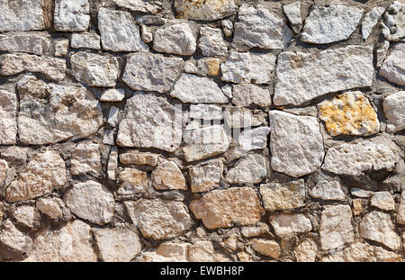 Fragment of a gray stone wall as background Stock Photo