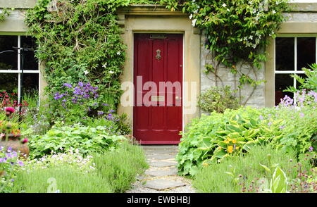 A traditional English cottage garden frames the path to a country cottage in the Peak District National Park, England, UK summer Stock Photo