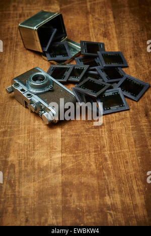 Vintage old retro film camera and old empty paper frame photos on wooden background. Nostalgic style picture, memories, Stock Photo