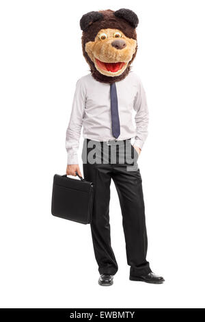 Full length portrait of a silly young businessman wearing a childish bear mask on his head and holding a suitcase Stock Photo