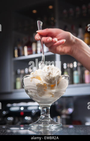 a glass of ice-cream stands on the bar Stock Photo