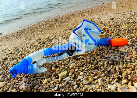 Scuba mask and snorkel on the rocky shore of the pond Stock Photo