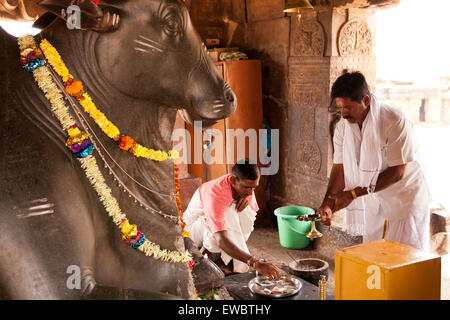 Priester vor der Nandi-Statue im Virupaksha Tempel aus der Chalukya-Dynastie, UNESCO-Welterbe in Pattadakal, Karnataka, Indien,  Stock Photo