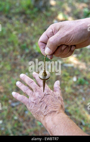 Water diviner with a pendulum Stock Photo