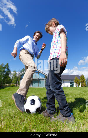 father and son playing football Stock Photo
