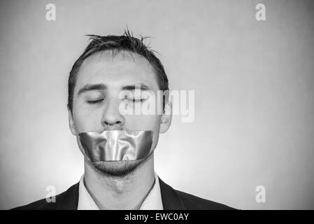 Photo of a young man with sellotape covering his mouth Stock Photo