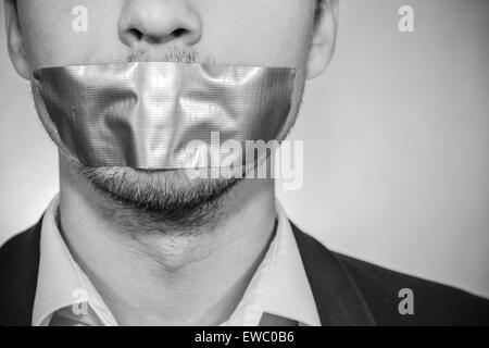 Photo of a young man with sellotape covering his mouth Stock Photo