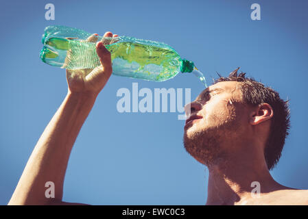 Photo of a man who's face is covered with water. Beautiful sky in the background. Stock Photo