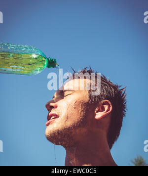 Photo of a man who's face is covered with water. Beautiful sky in the background. Stock Photo