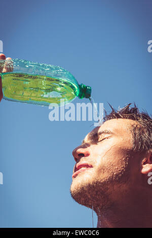 Photo of a man who's face is covered with water. Beautiful sky in the background. Stock Photo