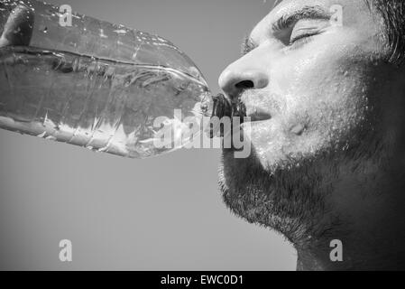 Photo of a man who's face is covered with water. Beautiful sky in the background. Stock Photo