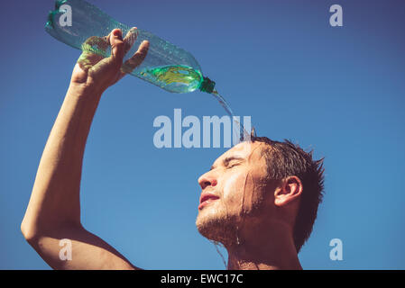 Photo of a man who's face is covered with water. Beautiful sky in the background. Stock Photo