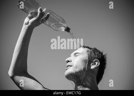 Photo of a man who's face is covered with water. Beautiful sky in the background. Stock Photo