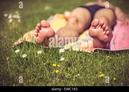 Photo of a young man that is sunbathing. A lot of greenery in the foreground Stock Photo
