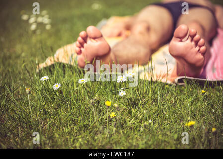 Photo of a young man that is sunbathing. A lot of greenery in the foreground Stock Photo