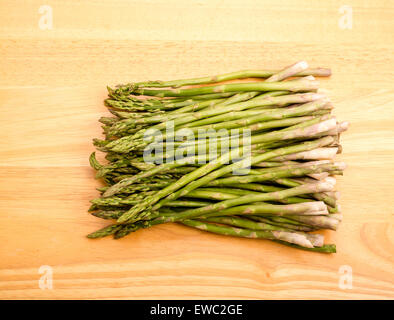 A bunch of fresh, green asparagus on a wood cutting board Stock Photo