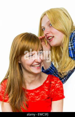 Blonde caucasian teenage girl whispering in ear of redhead girlfriend isolated on white background Stock Photo