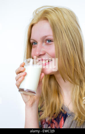 Blond caucasian teenage girl drinking glass of milk isolated on white background Stock Photo