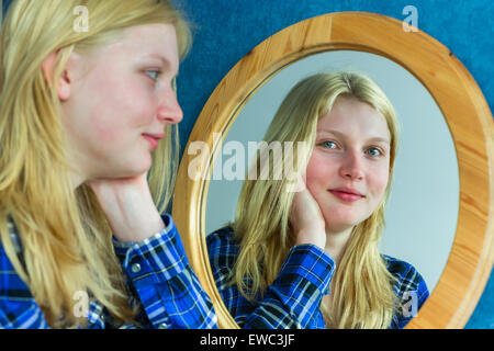 Blonde teenage dutch girl looking in mirror Stock Photo