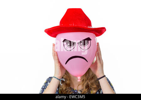 Girl holding pink balloon with angry face and red hat isolated on white background Stock Photo