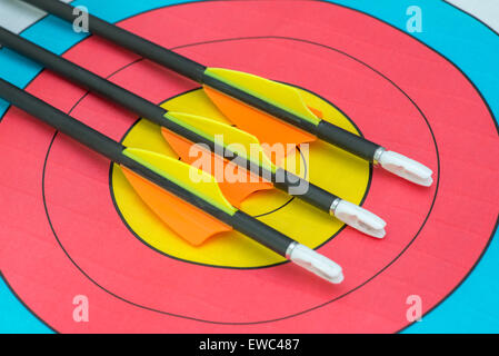 Three arrows sitting on bullseye of a paper target Stock Photo