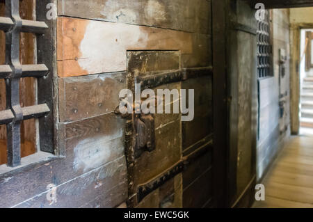 Heavy wooden medieval prison cell door with open hatch showing prisoner ...