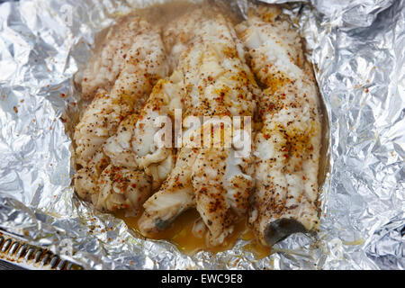 seasoned cod fillets cooked in aluminium foil on a bbq Reykjavik iceland Stock Photo