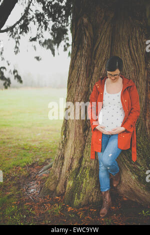 Portrait of a pregnant woman holding her belly. Stock Photo