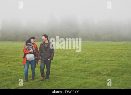 Portrait of a young family walking in the park. Stock Photo