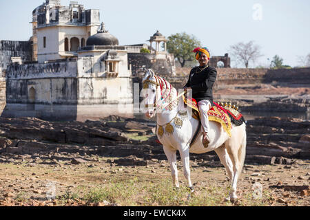 Marwari Horse. Dominant white dancing horse decorated with colourful headgear with its proud owner in front of Chittorgarh Fort. Stock Photo