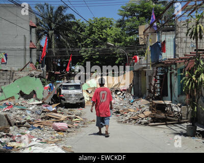 Manila, Philippines. 23rd June, 2015. A resident of Sarmiento Street walks through the remains of homes that were demolished last June 16, as the community protests the impending demolition of homes in the area. Residents demanded the local government of Manila to halt the planned demolition of their homes, alleging that the projects planned for the place are alibis to accommodate a bus company owned by Guia Gomez, one of the many mistresses of Manila mayor Joseph Estrada. Credit:  Richard James Mendoza/Pacific Press/Alamy Live News Stock Photo