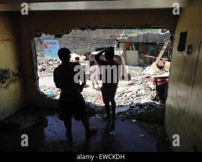 Manila, Philippines. 23rd June, 2015. Residents of Sarmiento Street, whose homes were demolished last June 16, have a conversation inside a demolished home. Residents demanded the local government of Manila to halt the planned demolition of their homes, alleging that the projects planned for the place are alibis to accommodate a bus company owned by Guia Gomez, one of the many mistresses of Manila mayor Joseph Estrada. Credit:  Richard James Mendoza/Pacific Press/Alamy Live News Stock Photo