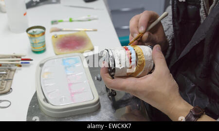 dental technician in the technical laboratory manufactures ceramic bridge for doctors Stock Photo