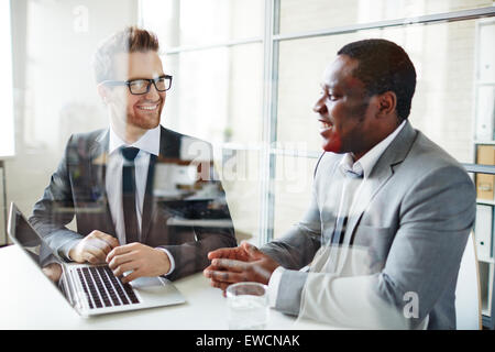 Two male colleagues discussing data at meeting Stock Photo