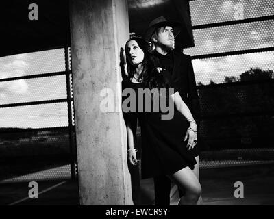 Man and woman together, concrete building surroundings, black and white image Stock Photo