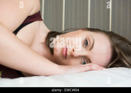 Beautiful young woman lying in bed Stock Photo