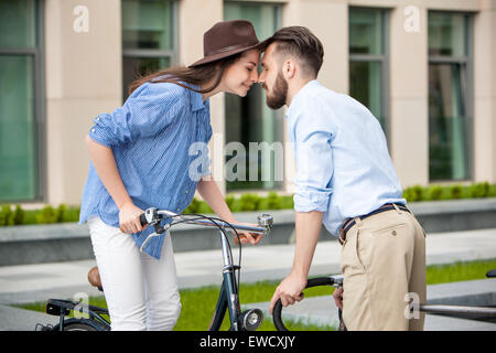 Romantic date of young couple on bicycles at street Stock Photo