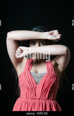 Scared woman in danger hiding face with hands Stock Photo