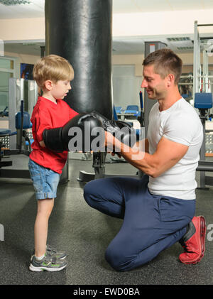 Boy with personal trainer boxing in gym Stock Photo