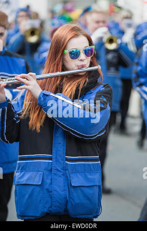 Young woman with red hair playing flute in Cologne Carnival Parade 2014 Stock Photo