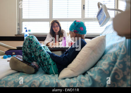 Doctor next to young patient's bed in pediatric hospital ward Stock Photo
